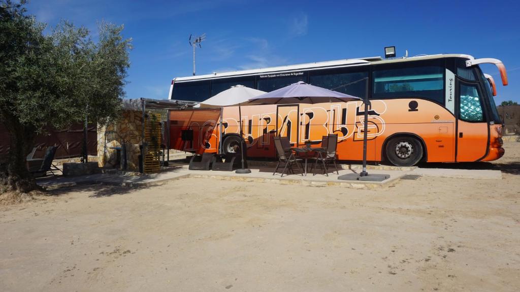 马德里cuchibus的停在桌子和雨伞旁边的橙色巴士