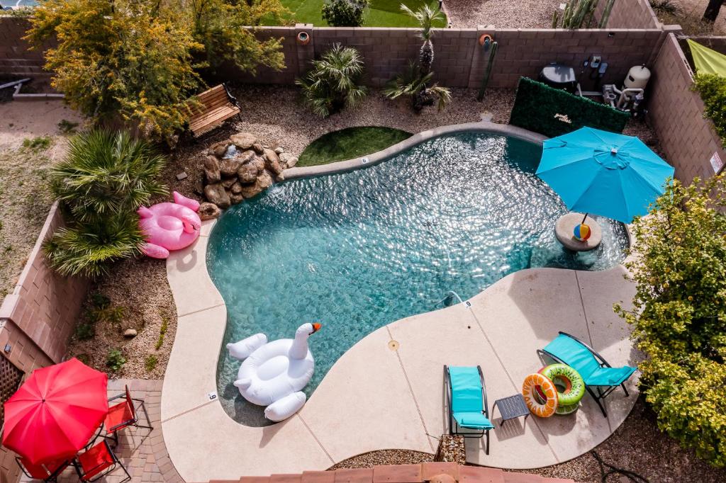 凤凰城Chic Poolside Oasis - Karaoke - BBQ - Games的享有带遮阳伞和椅子的游泳池的顶部景致