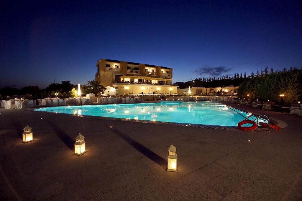 雅典德科里亚酒店的大楼前带灯的大型游泳池