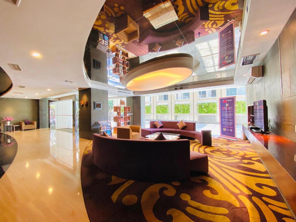 雅加达Habitare Apart Hotel Rasuna Jakarta Powered by Archipelago的客厅配有沙发和桌子