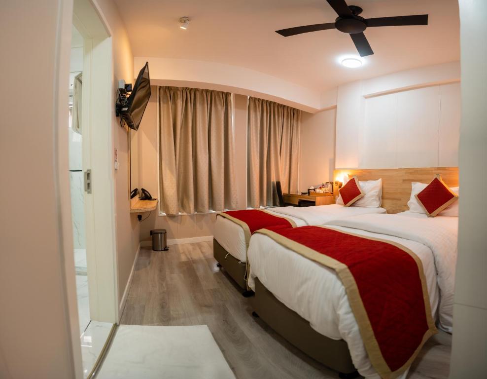 马累Tourist Inn Grand的酒店客房配有两张床和吊扇。