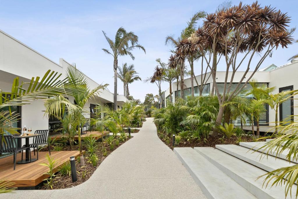 安吉西大洋路度假酒店的棕榈树建筑前的走道