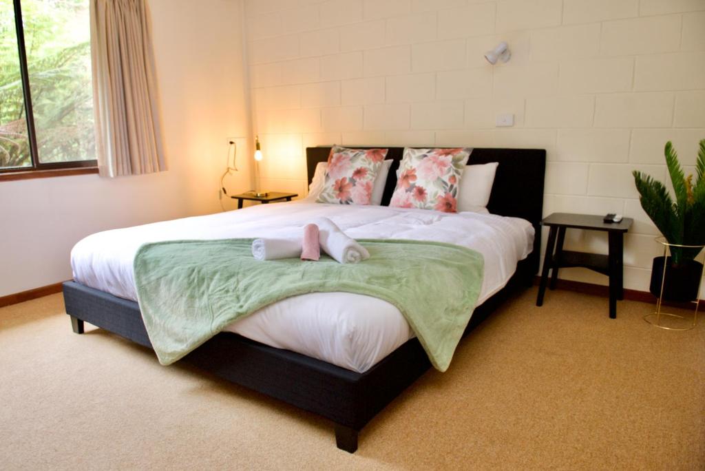 沃伯顿Green Gables Warburton - King Garden Suite的一间卧室配有一张大床和两条毛巾