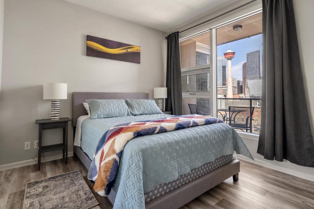 卡尔加里City View 1BR Downtown Calgary的一间卧室设有一张床和一个大窗户