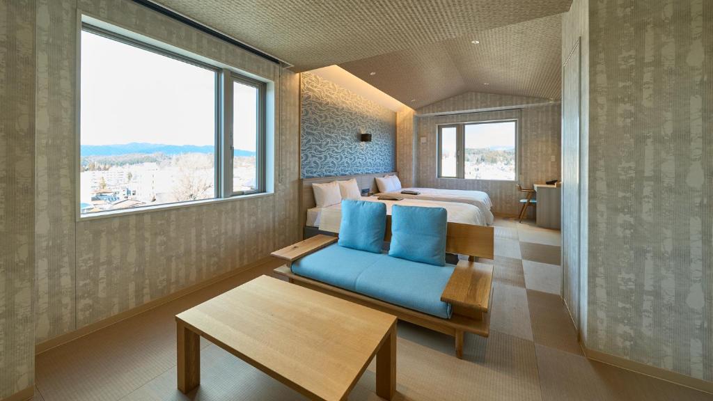 高山Hotel and Spa Gift TAKAYAMA的酒店客房,配有床和蓝色的沙发