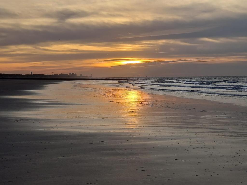 米德尔克尔克Caravan Aan Zee Arnani的日落在海滩上,享受阳光