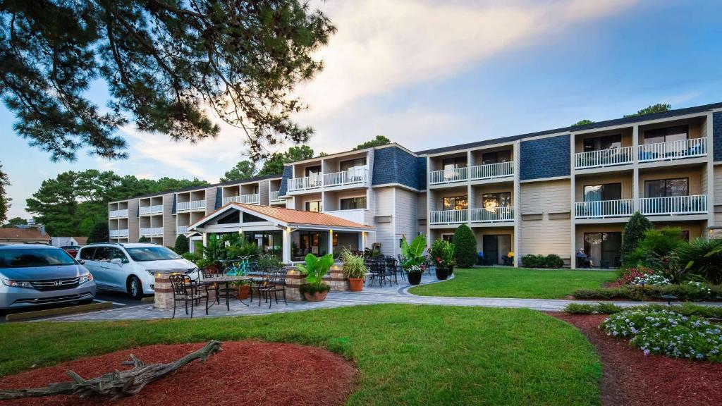 钦科蒂格Best Western Chincoteague Island的公寓大楼设有庭院和停车场