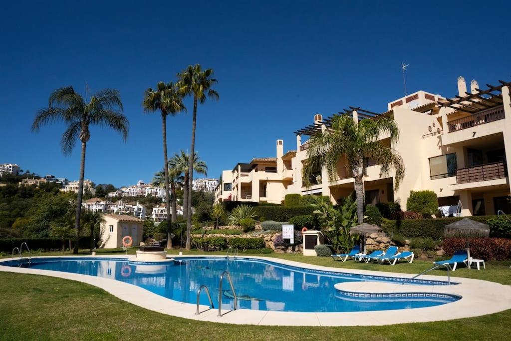 贝纳阿维斯Los Piños, 2 Bedroom Apartment with panoramic view的棕榈树建筑前的游泳池