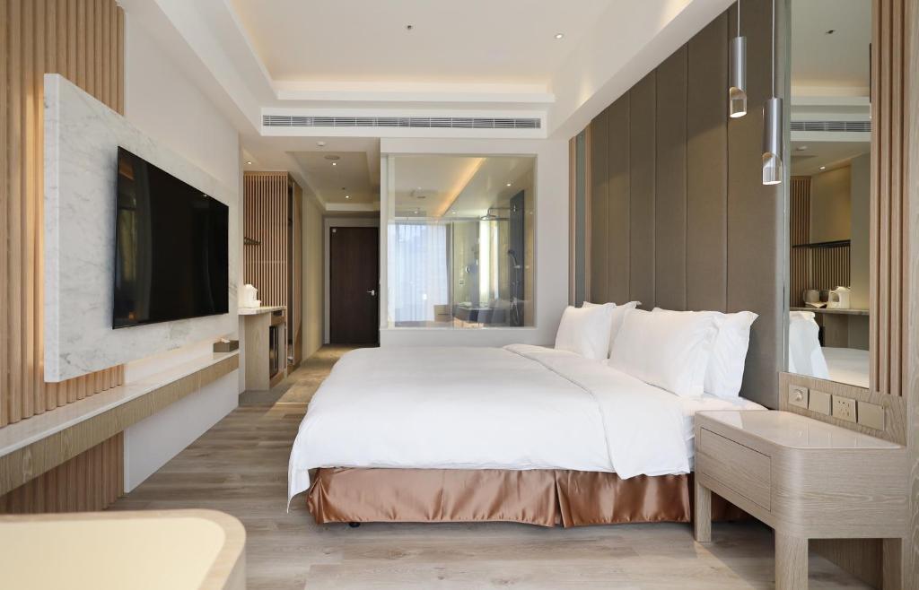 礁溪Gamalan Star Hotel的卧室配有一张白色大床和电视。