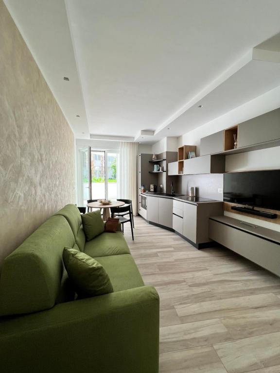 滨海波利尼亚诺Vilu Suite Centro的一间带绿色沙发的客厅和一间厨房