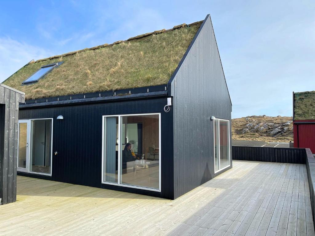 SandurCaptains Cottage的一座带草屋顶的黑色房子