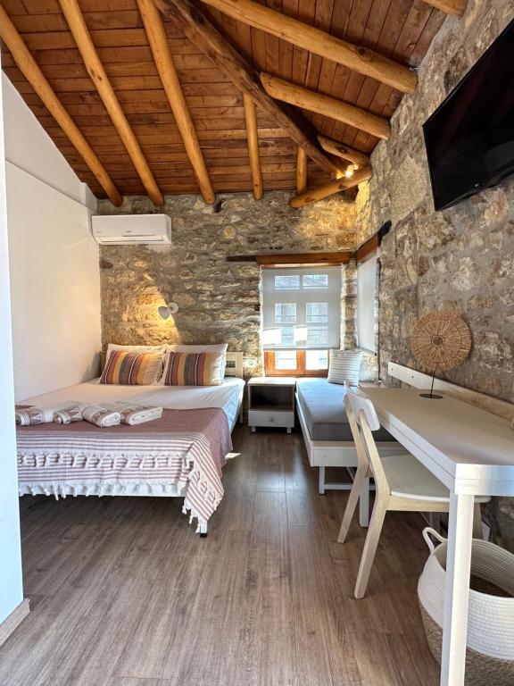 阿菲托斯Casa La Bohema的一间卧室设有两张床和石墙