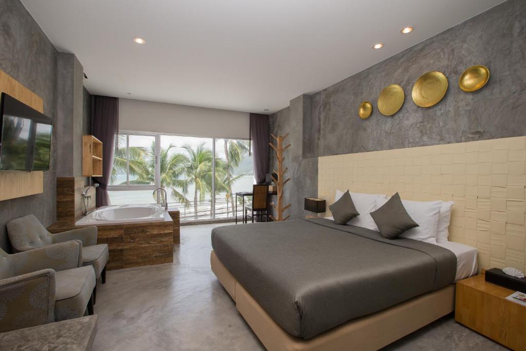 芭东海滩Patong Signature Boutique Hotel的一间卧室配有一张床和一个浴缸,毗邻一间浴室