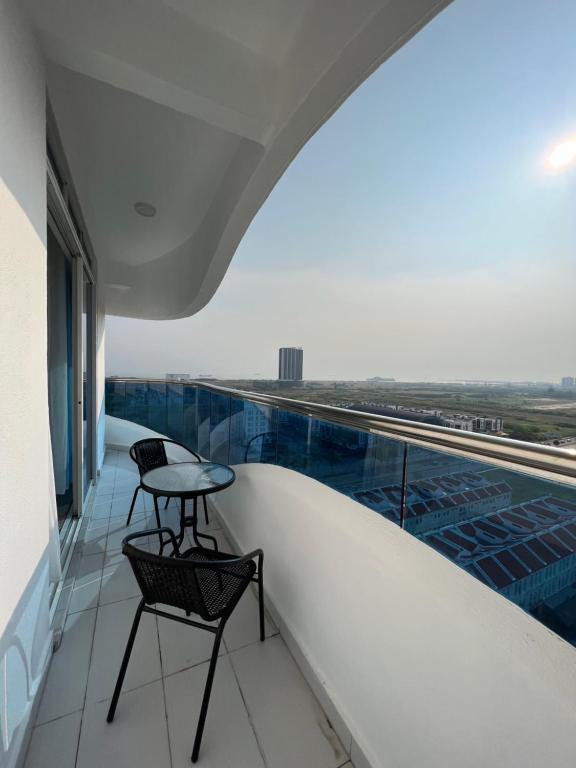 马六甲SNHomestay1826 Sea View @ The Wave Residence的大楼内的阳台配有桌椅