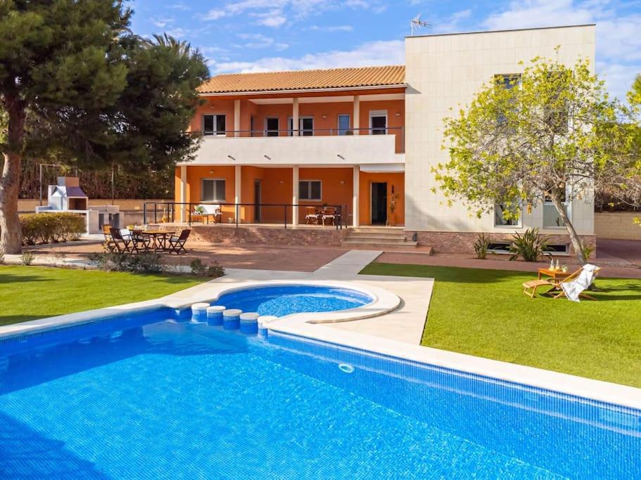 阿利坎特Acogedora Villa en Alicante capital con barbacoa的房屋前的游泳池
