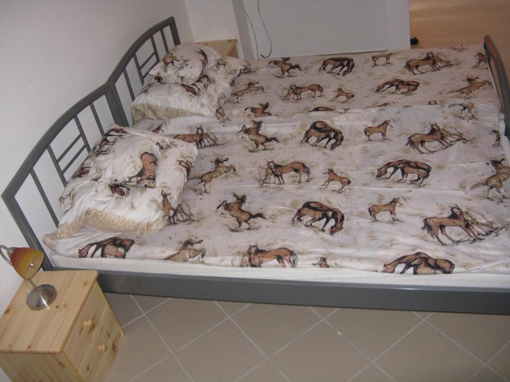 布达佩斯卡尔帕蒂汽车旅馆的床上有一条毯子,上面有马匹