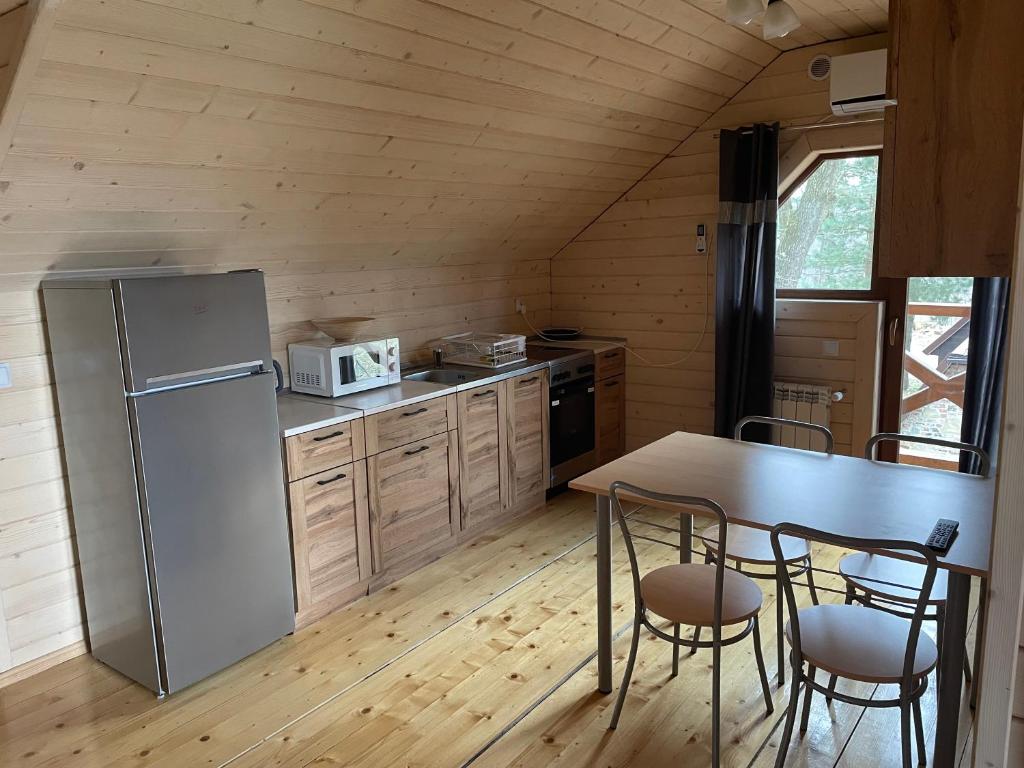 GraboszyceSosnowy Domek Piętro的厨房配有冰箱和桌椅