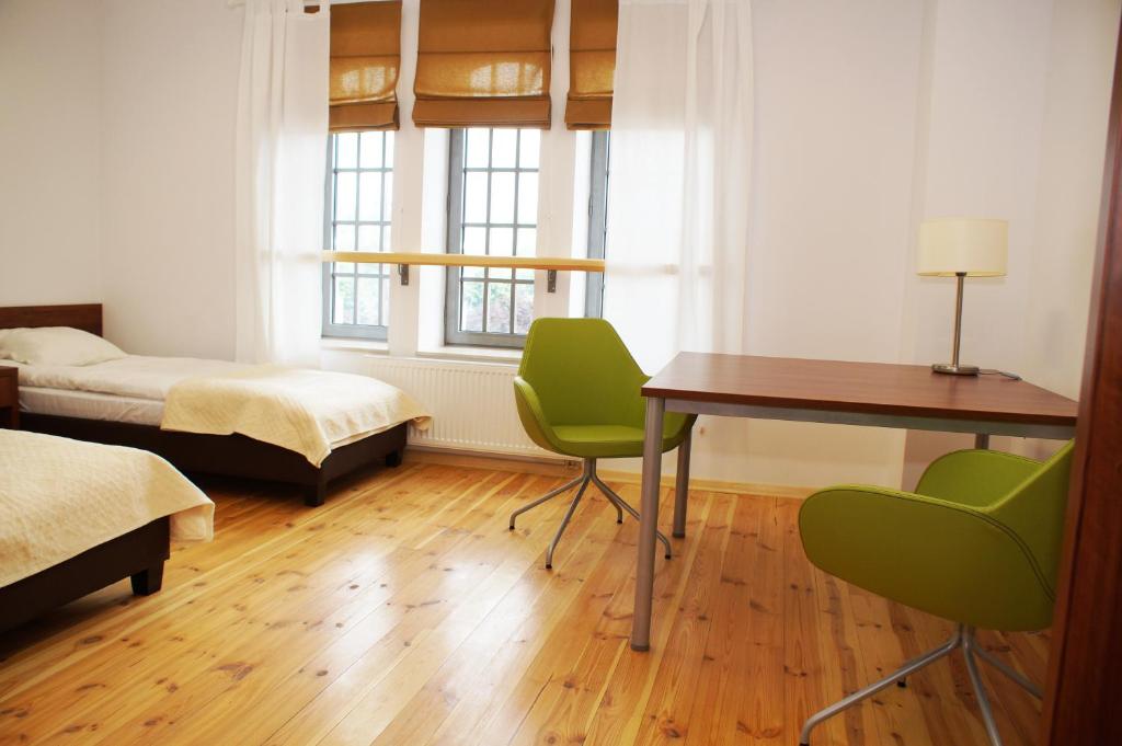 托伦Hostel Międzynarodowe Centrum Spotkań Młodzieży的一间卧室配有书桌、一张床和一张桌子及椅子