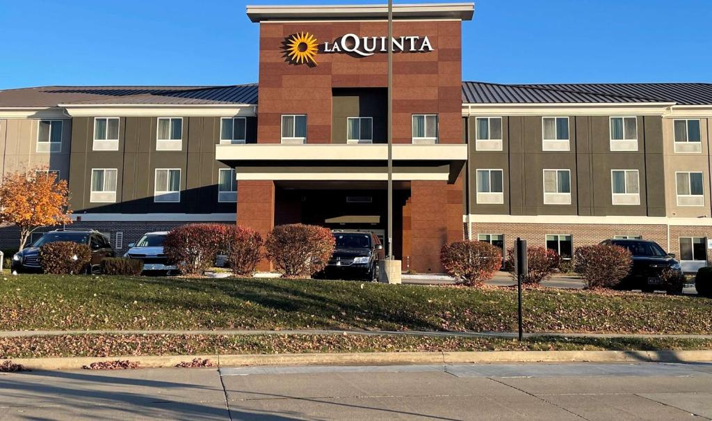 安克尼La Quinta Inn & Suites by Wyndham Ankeny IA - Des Moines IA的前面有太阳神的标志的建筑