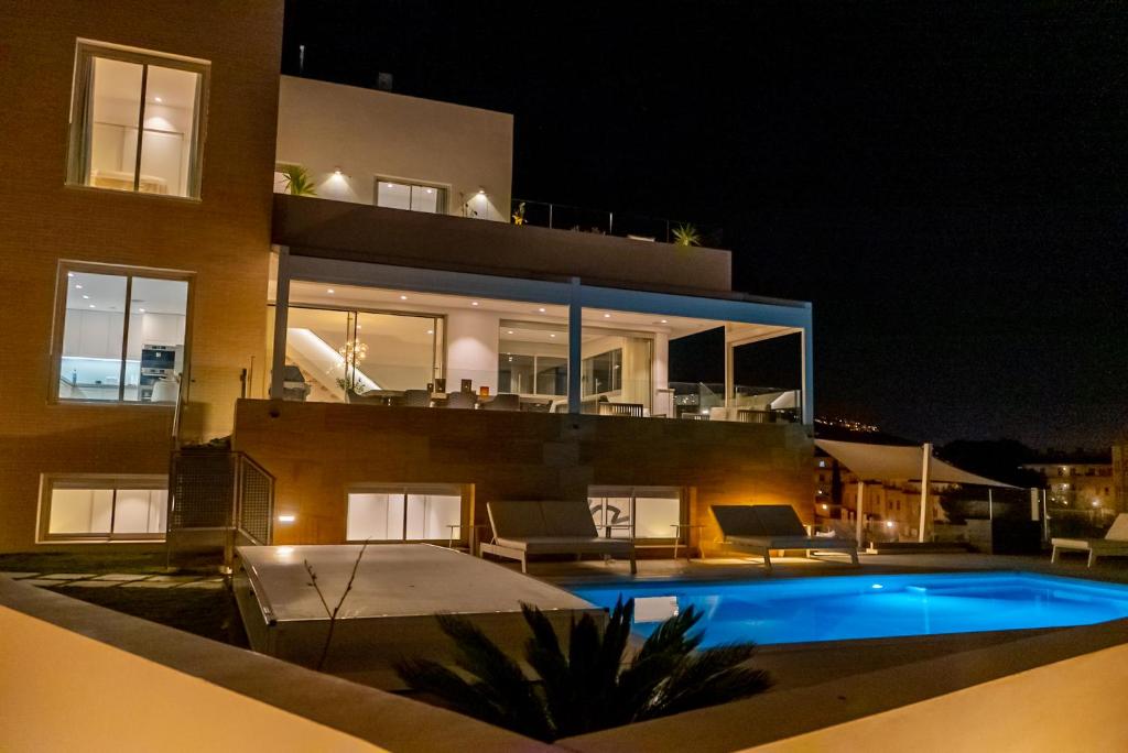 福恩吉罗拉Villa Palm Beach - Incredible villa with 5 rooms, amazing sea view and private pool的一座晚上设有游泳池的房子