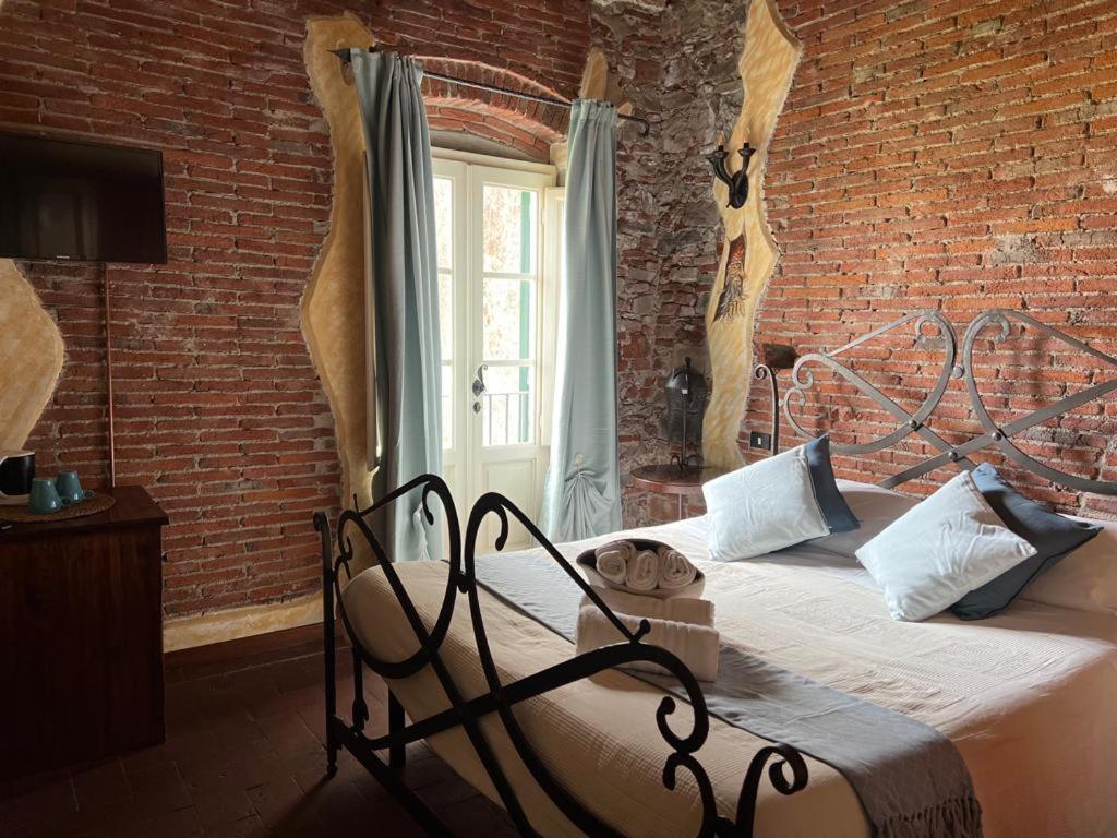 卢卡Corte Dei Folletti的卧室配有砖墙内的床铺