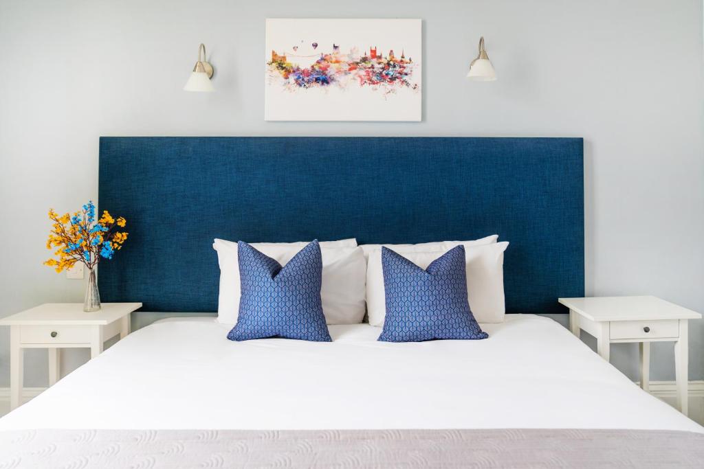 布里斯托克利夫顿华盛顿酒店的一间卧室配有一张大床和蓝色床头板