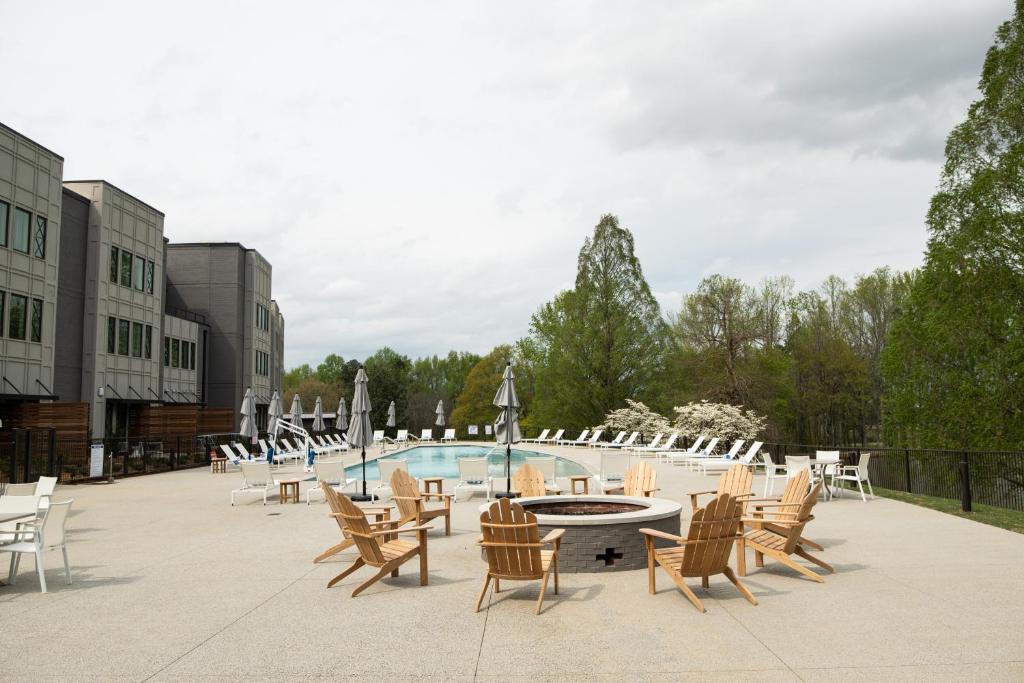 格林维尔Hotel Hartness的一个带桌椅的庭院和一个游泳池