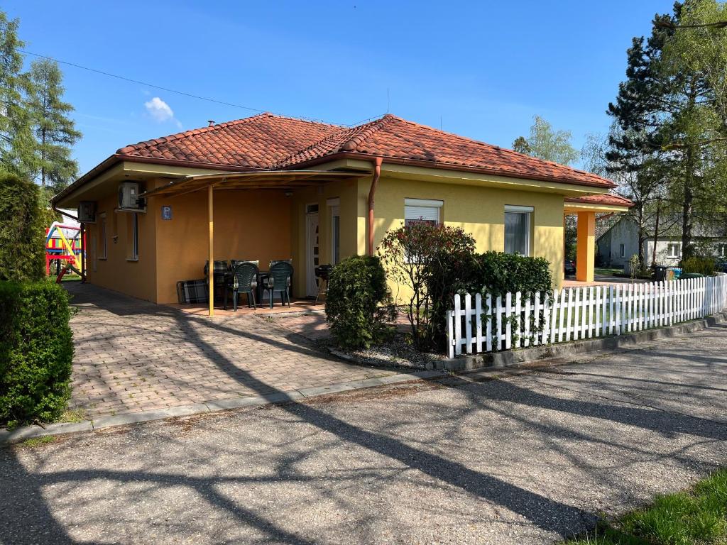 帕廷斯Villa Gracia Patince的白色围栏的黄色小房子