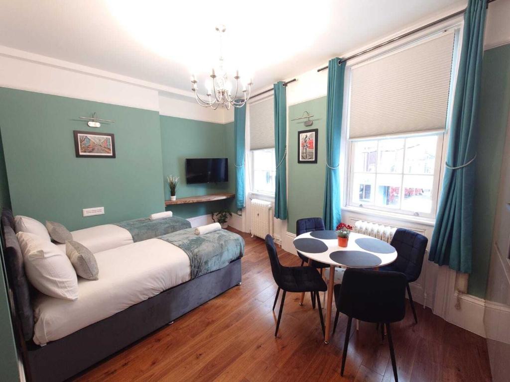 伦敦Kings Cross Apartment的卧室配有一张床和一张桌子及椅子