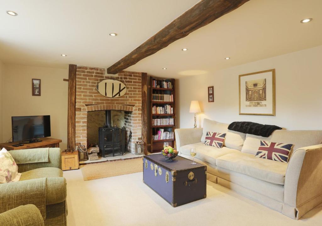 米尔登霍尔Walnut Tree Cottage的带沙发和壁炉的客厅