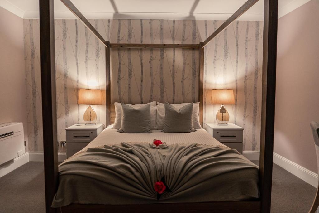卡斯特Le Pommier的一间卧室配有一张大床和两盏灯