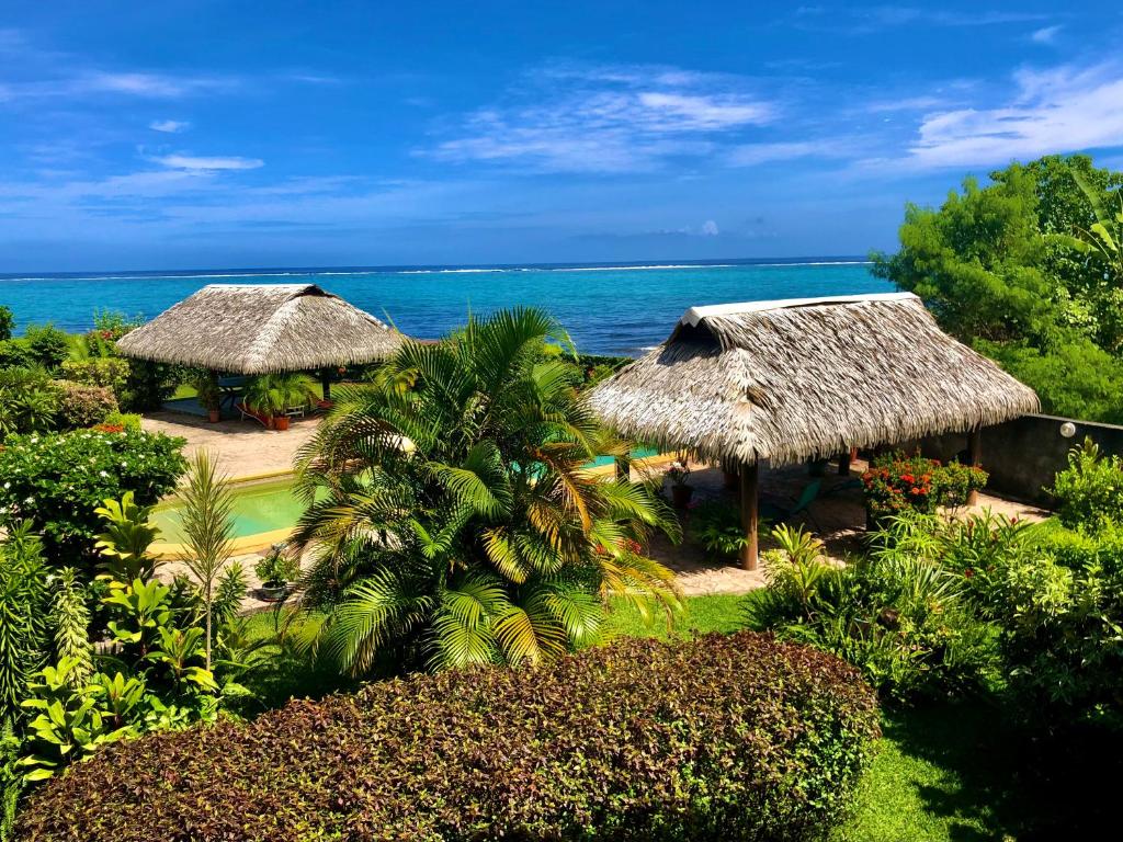 PaeaSuperbe bord de mer, accès lagon et piscine privée的拥有2间茅草小屋和海洋的度假酒店