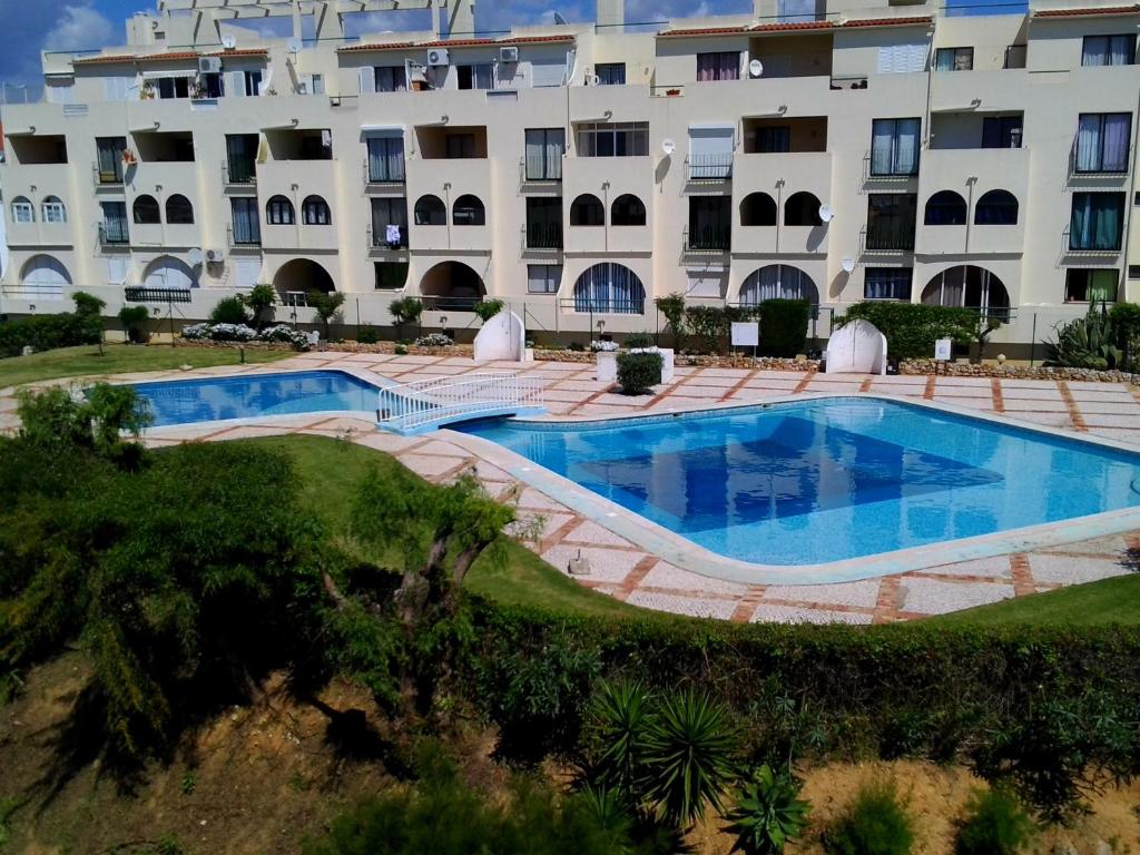 阿尔布费拉Apartamentos Poente da Aldeia的一座大型建筑,前面设有一个游泳池