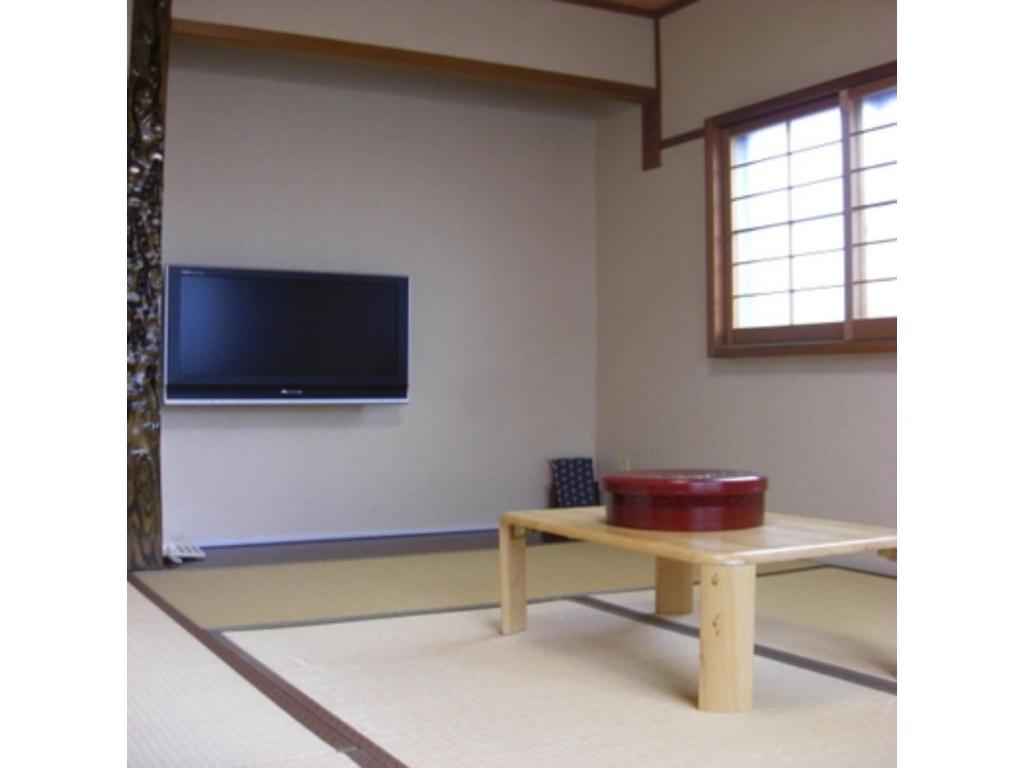 高山Minshuku Kuwataniya - Vacation STAY 96480v的一间设有桌子和墙上电视的房间