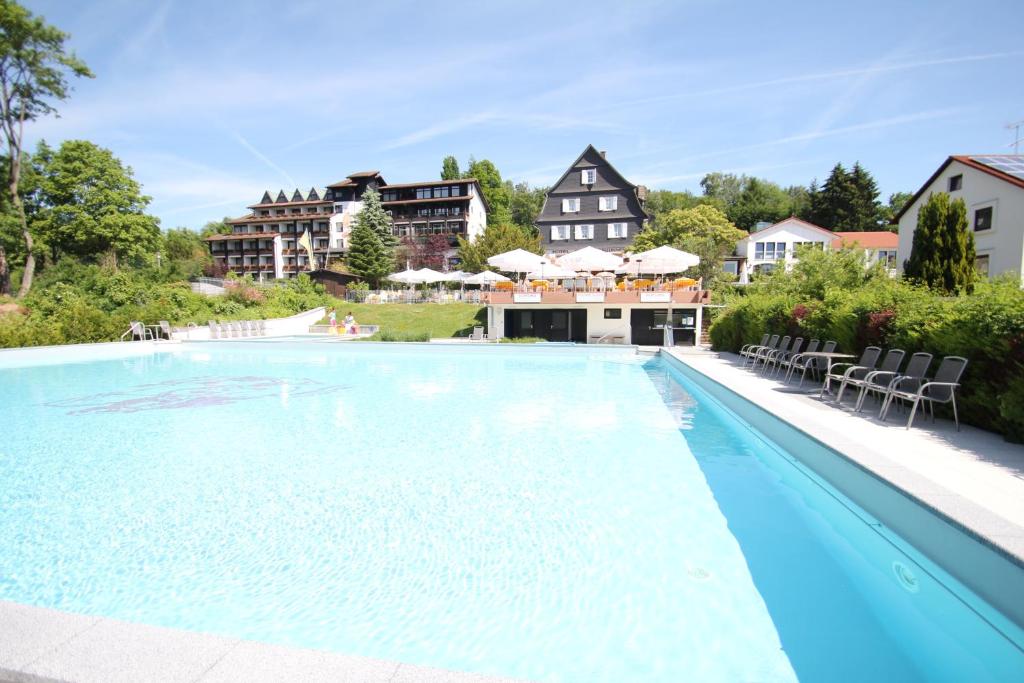Grasellenbach赛弗里德布鲁门环形酒店的一个带椅子的游泳池和一个背景房子