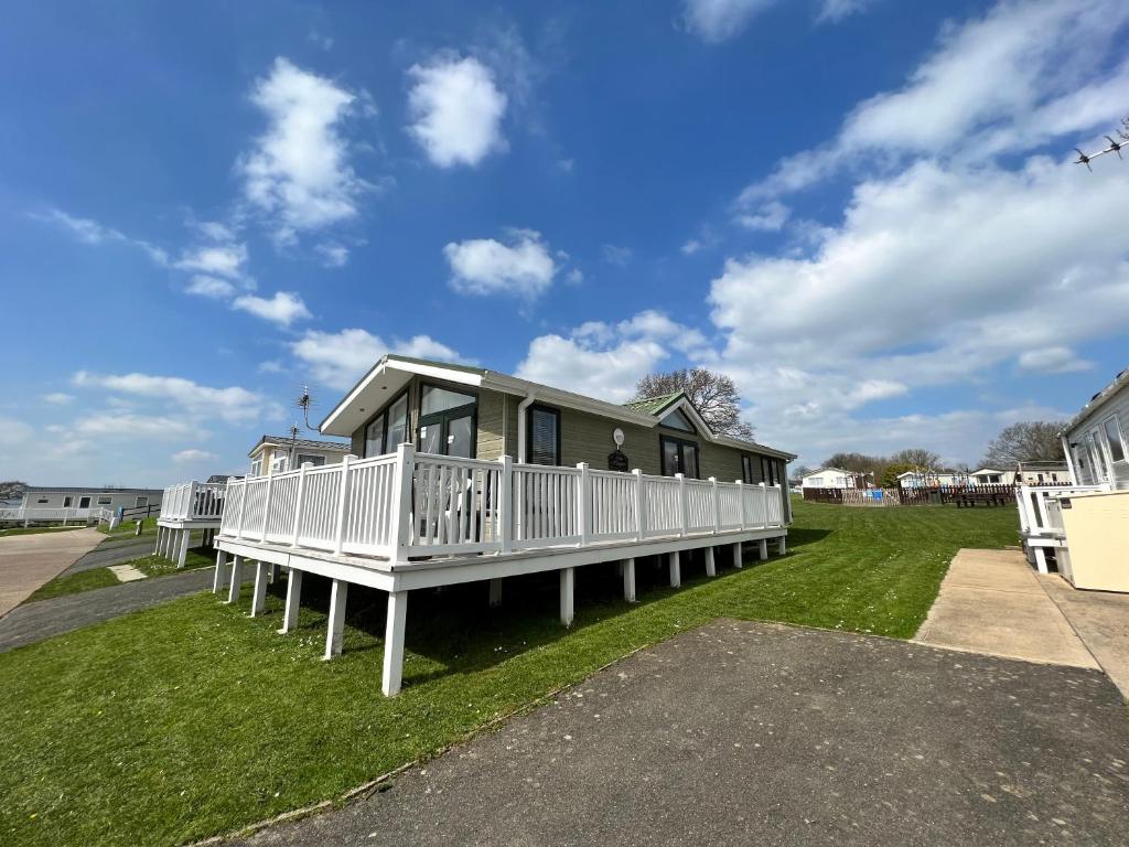 Saint Helens2 Bedroom Lodge TH35, Nodes Point, St Helens, Isle of Wight的草上门廊的房子