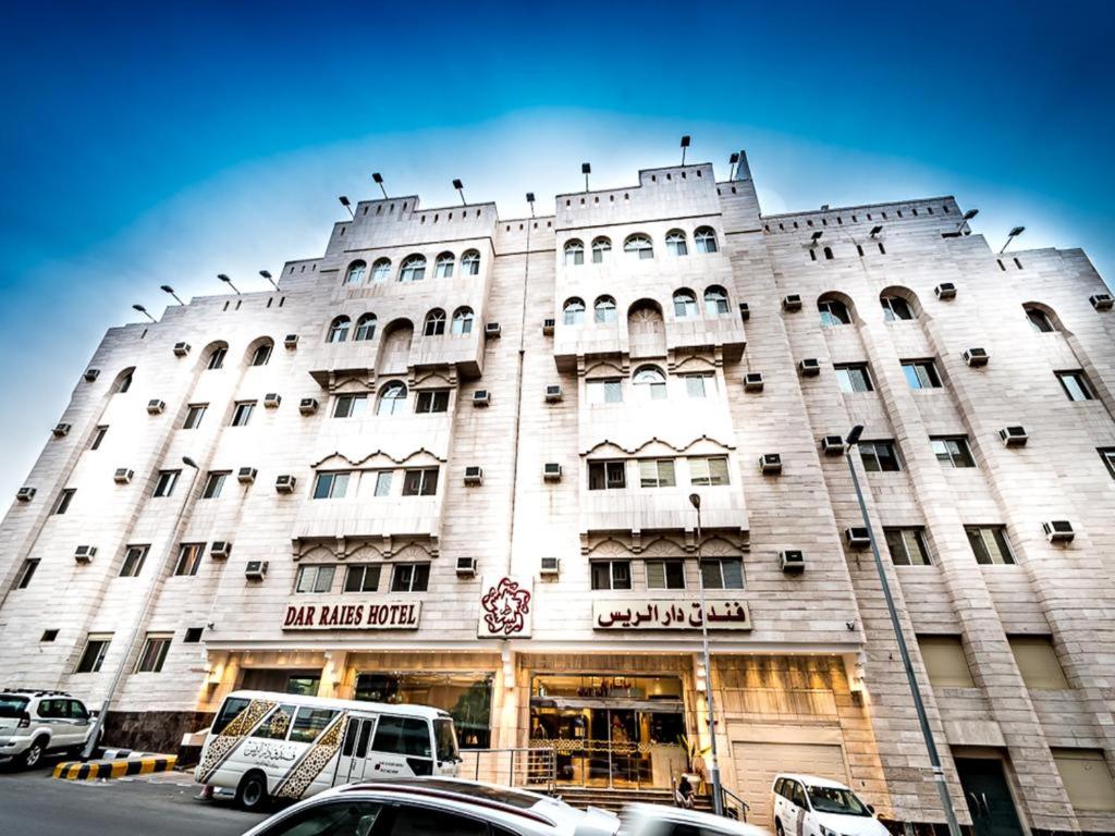 麦加فندق دار الريس - Dar Raies Hotel的一座白色的大建筑,前面有汽车停放