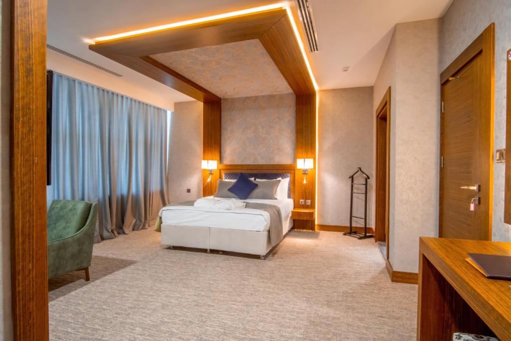 代胡克Parwar Hotel的酒店客房,配有一张床和一把绿色椅子
