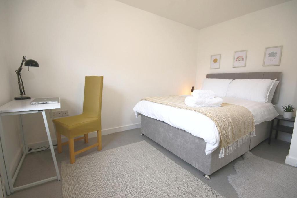 朗伊顿Double bed with Parking Desk TV Wi-Fi in Modern Townhouse in Long Eaton的一间卧室配有一张床、一张桌子和一把椅子