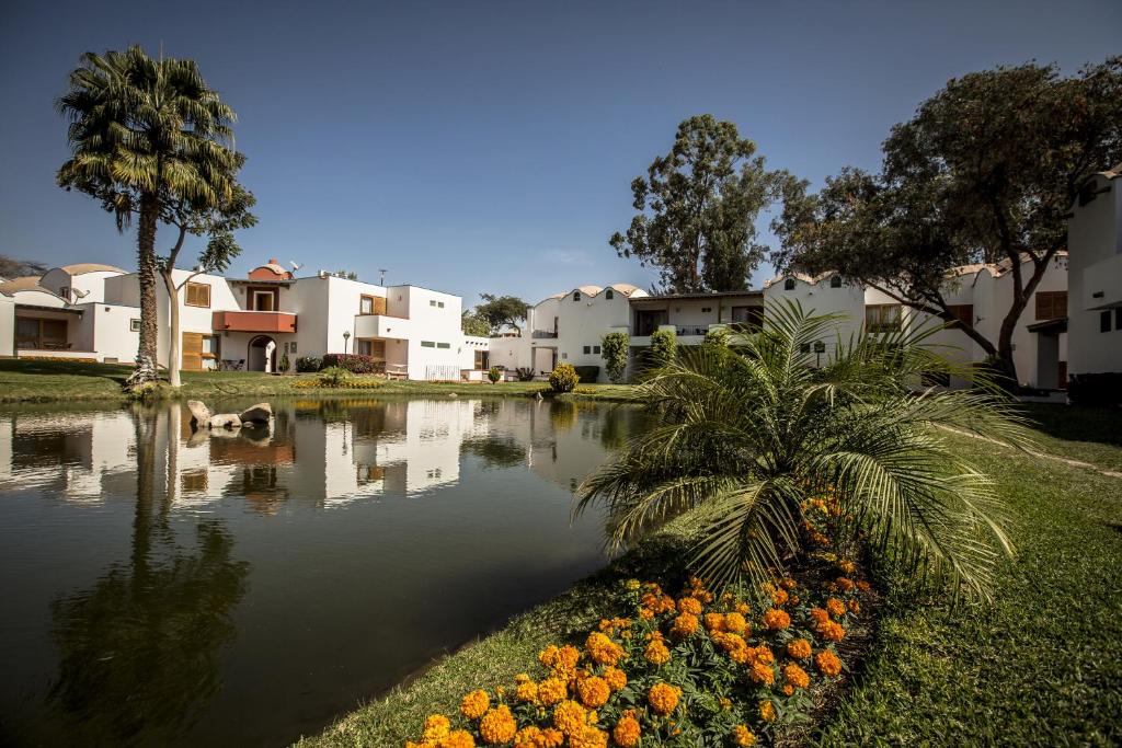 伊察拉斯登纳斯酒店的种着棕榈树和鲜花的池塘