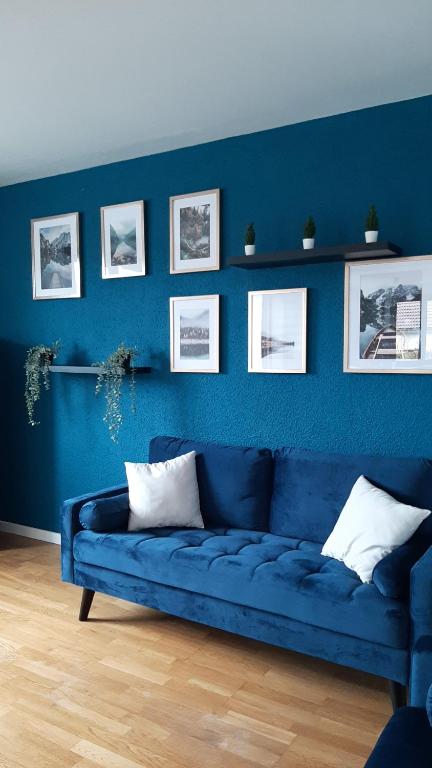 ChevryA 6 mns de la station de ski Crozet, proche Genève的客厅里设有蓝色的沙发,拥有蓝色的墙壁