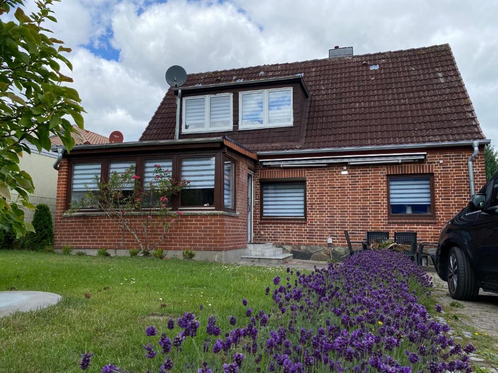 沙博伊茨Strandnähe的前面有紫色花的房屋