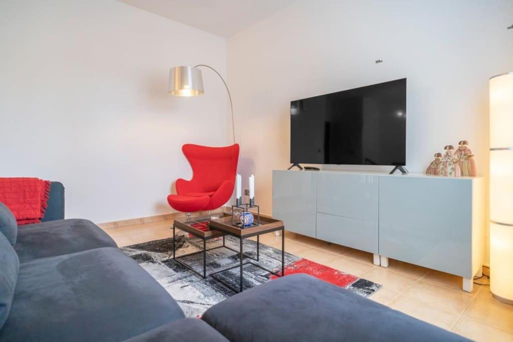 阿尔豪林格朗德Beautiful penthouse with spectacular views.的客厅配有红色椅子和电视