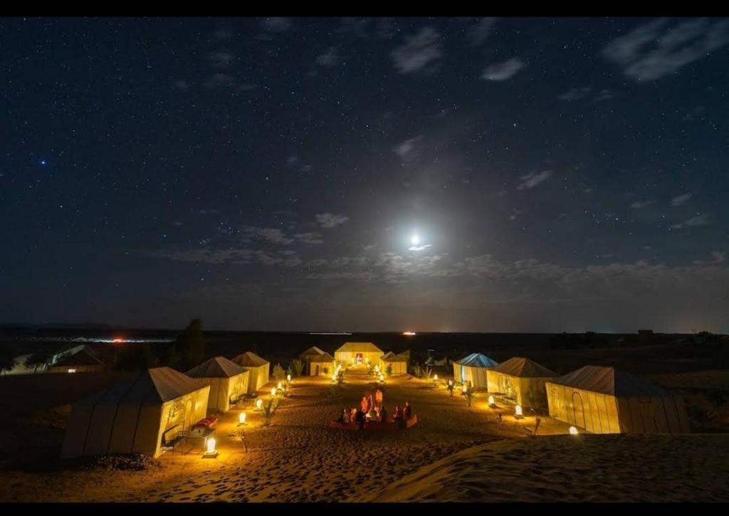 梅尔祖卡梅尔祖卡沙丘帐篷营地的一群人晚上站在田野里