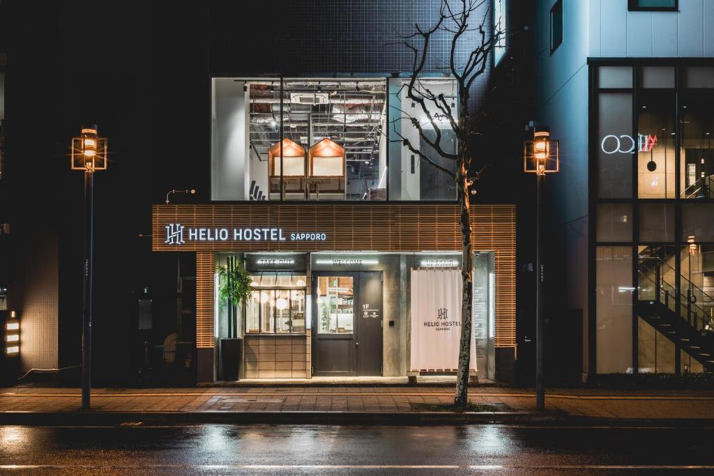 札幌HELIO HOSTEL SAPPORO的夜间在建筑物前的商店