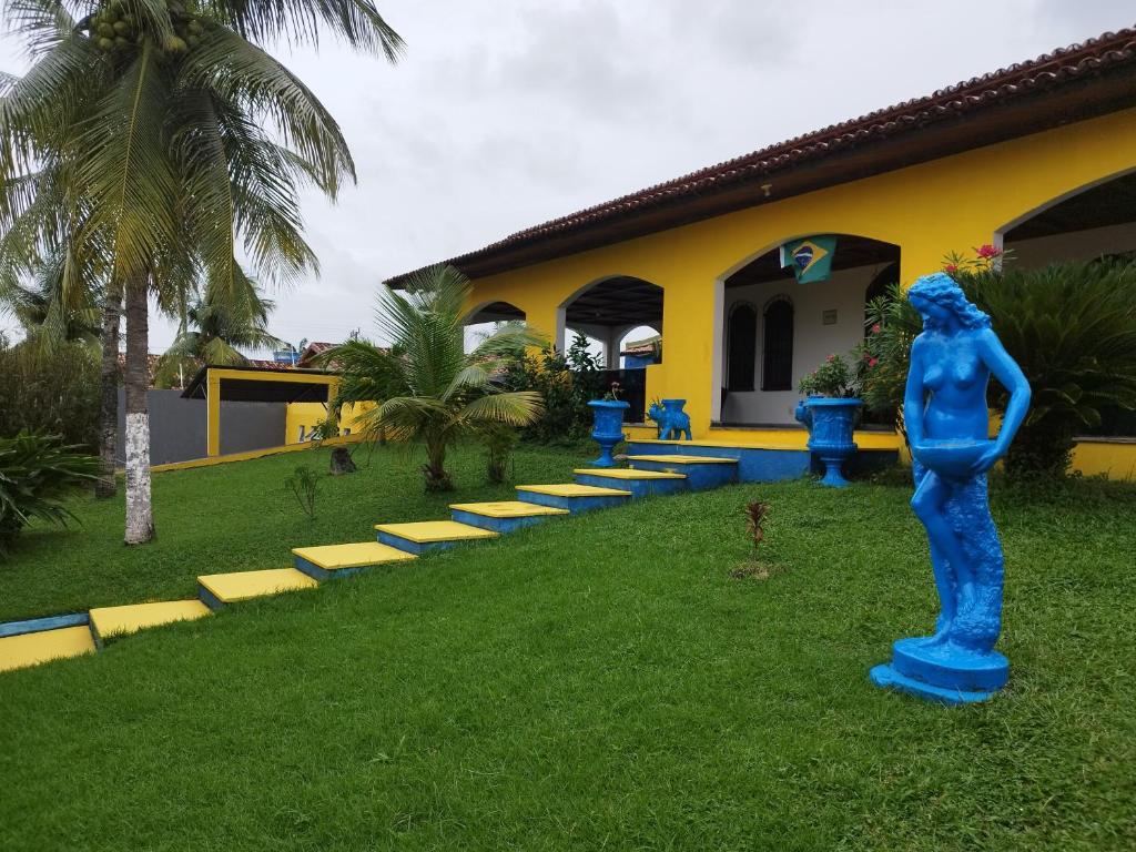 萨利诺波利斯Casa com Piscina 50000 litros Área Gourmet 3 Suites no Destacado, Bairro mais Nobre de Salinas的建筑前草上的蓝色雕像