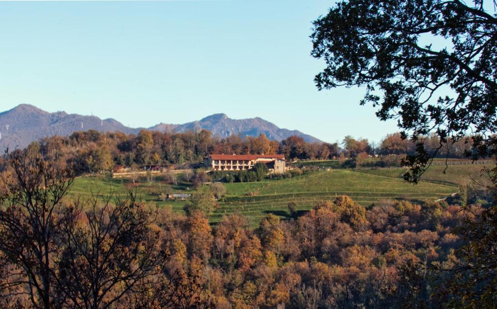 布雷西亚Agriturismo Cascina Margherita的田野中间的山丘上的房子