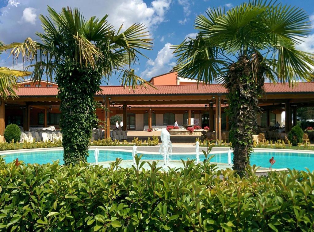 Castropignano德维里别墅酒店的拥有两棵棕榈树和一个喷泉的度假村