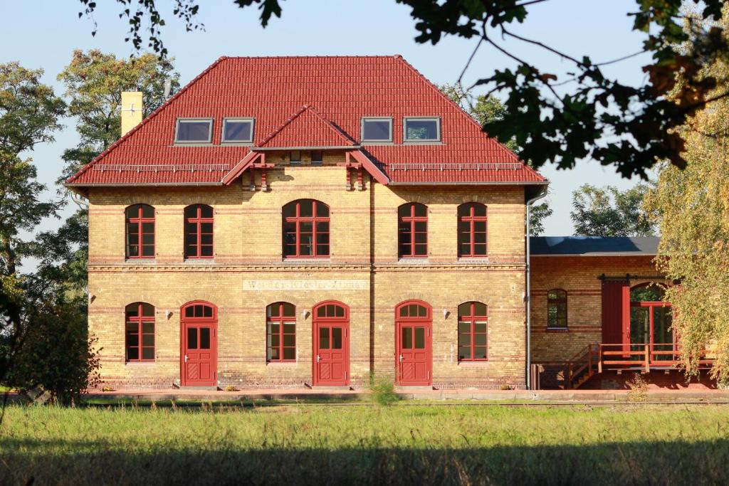 于特博格Ferienwohnungen Bahnhof Werder的红色门和红色屋顶的房子