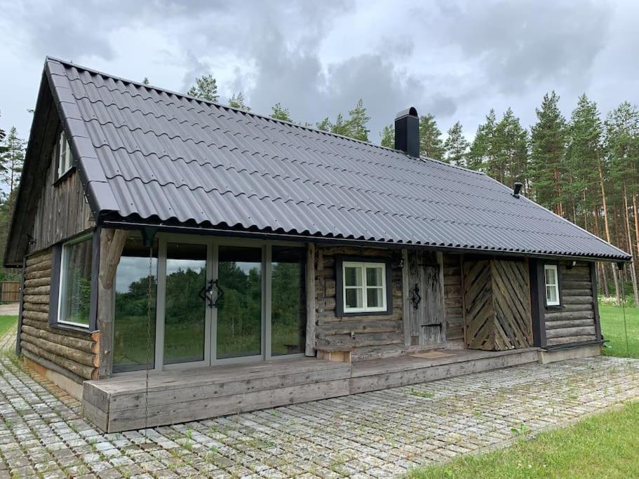 LiigalaskmaPrivate sauna house with sea view的小木屋,设有金属屋顶和窗户